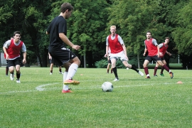 The men's soccer team practicing in red jerseys.